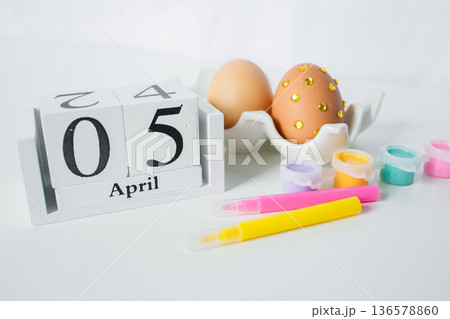 Christian Catholic Easter 2026 date on a wooden calendar with Easter eggs and paints for decoration on white background close up Christian Catholic Easter 2026 date on a wooden calendar with Easter eggs and paints for decoration on white background close up 136578860