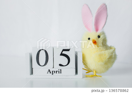 Christian Catholic Easter 2026 date on a wooden calendar with funny small Easter chick toy on white background close up Christian Catholic Easter 2026 date on a wooden calendar with funny small Easter chick toy on white background close up 136578862
