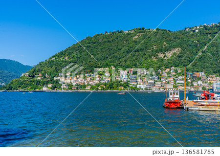 Como lake water in Summer day. Multicolor houses on green mountains Italian travel. Italy Como lake water in Summer day. Multicolor houses on green mountains Italian travel. Italy 136581785