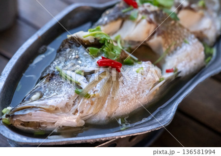 Streamed Seabass Fish with lime served on plate, a popular, healthy dish featuring delicate white fish drenched in a tangy, spicy, and garlicky sauce Streamed Seabass Fish with lime served on plate, a popular, healthy dish featuring delicate white fish drenched in a tangy, spicy, and garlicky sauce 136581994