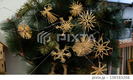 Straw Christmas Ornaments on Tree. Home winter decor Straw Christmas Ornaments on Tree. Home winter decor 136583208