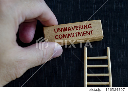 Leadership concept text on black cover with wooden ladder symbolizing responsibility, dedication, and steady upward growth toward excellence. 136584507