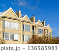Top of low-rise residential building on blue sky background 136585983