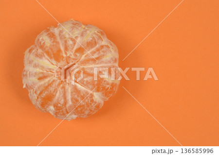 Peeled tangerine on orange background Peeled tangerine on orange background 136585996