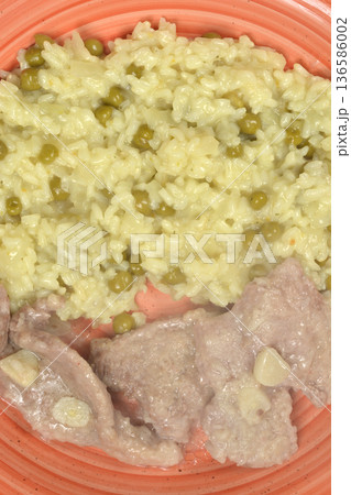 Pork medallions and risotto with peas on a plate 136586002