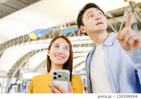 空港で案内を確認するカップル ■撮影協力：関西国際空港（KIX） 136586094