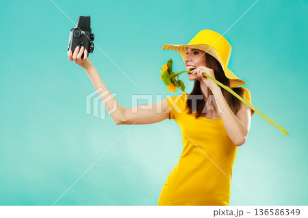 Summer woman holds sunflower old camera 136586349