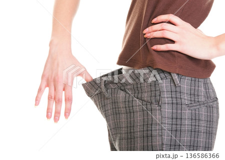 Woman showing how much weight she lost Woman showing how much weight she lost 136586366