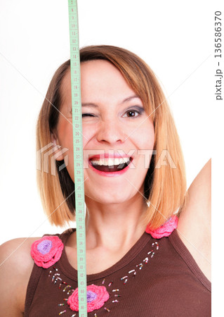 Beautiful young caucasian woman measuring her body with tape isolated Beautiful young caucasian woman measuring her body with tape isolated 136586370
