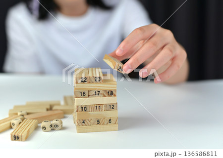 People were carefully placing small sticks on stacks of wooden sticks to complete their goals. People were carefully placing small sticks on stacks of wooden sticks to complete their goals. 136586811