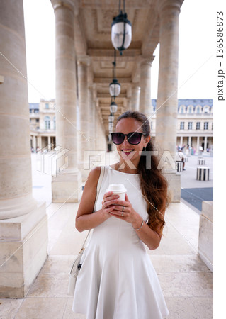 Woman using smartphone with coffee in Paris 136586873
