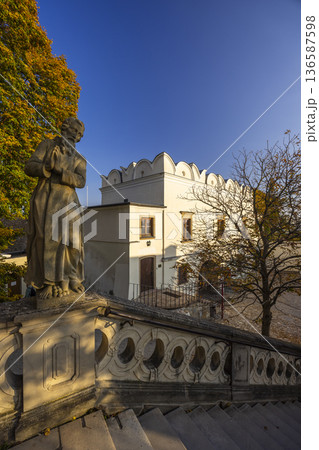 Praying statue on stairs overlooking historical building in Nitra 136587598