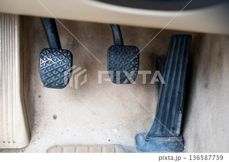 Dirty Car Pedals Brake, Accelerator, and Clutch in a Vehicle Footwell Dirty Car Pedals Brake, Accelerator, and Clutch in a Vehicle Footwell 136587739