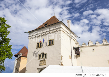 Kezmarok Castle tower with flags against blue sky 136587976