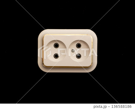 An old electrical outlet on a black background. An old electrical outlet on a black background. 136588186