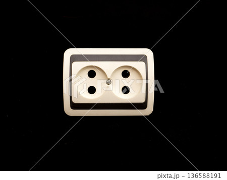 An old electrical outlet on a black background. An old electrical outlet on a black background. 136588191