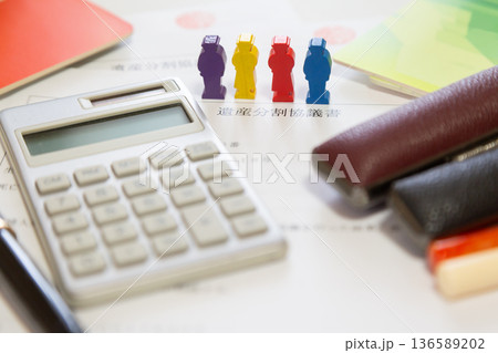 遺産分割協議書と木製ミニチュアの人々、計算機、印鑑、通帳　財産分与 相続 お金イメージ   136589202