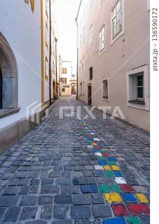 Passau, Germany - Apr 16, 2025: The very narrow, historic hell alley in the old town of Passau, Germany. 136590172