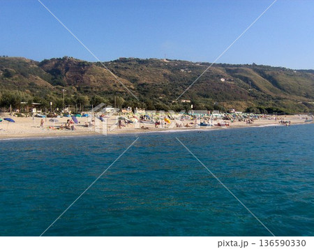 Beautiful panoramic view of the Calabrian coast during the summer season, featuring turquoise crystal-clear waters, dramatic rocky cliffs, and charming seaside scenery under bright blue skies. The Beautiful panoramic view of the Calabrian coast during the summer season, featuring turquoise crystal-clear waters, dramatic rocky cliffs, and charming seaside scenery under bright blue skies. The 136590330