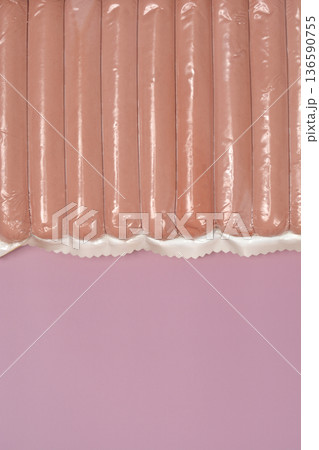 Vacuum sealed sausages on pink background 136590755