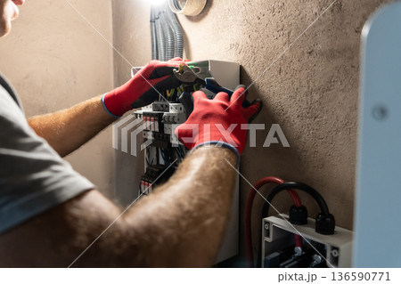 Electrician Working in Electrical Panel 136590771