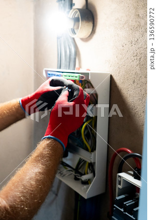Electrician Working in Electrical Panel Electrician Working in Electrical Panel 136590772