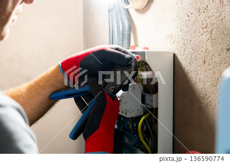 Electrician Working in Electrical Panel Electrician Working in Electrical Panel 136590774