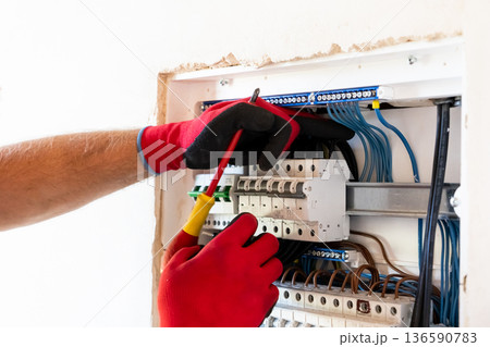 Electrician Working in Electrical Panel 136590783