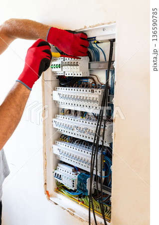 Electrician Working in Electrical Panel Electrician Working in Electrical Panel 136590785