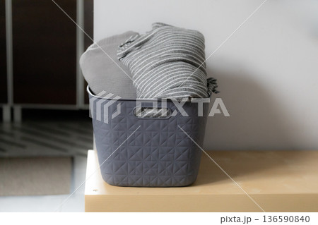 Basket with blanket placed on a wooden table in a modern living room space Basket with blanket placed on a wooden table in a modern living room space 136590840
