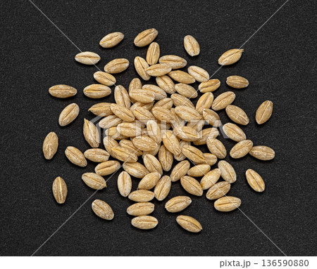 Barley grain pile on dark background, natural whole cereal ingredient, full depth of field, top view 136590880