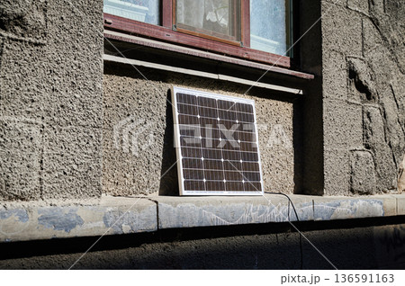 Photovoltaic solar panel in front of historical building. Concept of integration of sustainable renewable energy sources into old architecture. 136591163