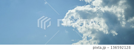 Bright blue sky with fluffy white clouds on a clear sunny day 136592128