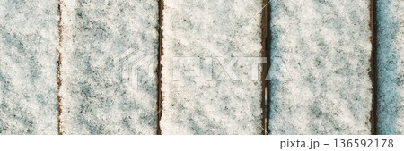 Snow-covered wooden planks create a textured pattern in winter cold weather Snow-covered wooden planks create a textured pattern in winter cold weather 136592178