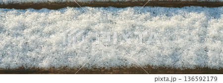 Snow-covered wooden surface with texture and soft lighting in winter setting Snow-covered wooden surface with texture and soft lighting in winter setting 136592179