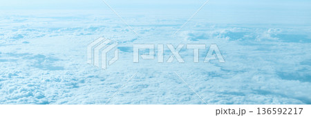 Expansive aerial view of cloudy sky and atmosphere from above with soft blue Expansive aerial view of cloudy sky and atmosphere from above with soft blue 136592217