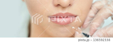 Close-up of female lips with injection for cosmetic enhancement by doctor 136592338