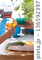 Fruit cocktail in beach bar, Two cocktail glasses cheers in the hands beach background.  136592397
