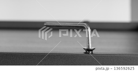 Metal Allen Key Engaged in Hex Screw on Dark Surface Metal Allen Key Engaged in Hex Screw on Dark Surface 136592625