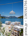 Served tables in a Greek tavern in Vathy Harbor, Meganisi island, Ionian Sea, Greece during the summer tourist season. Vertical. 136592766