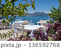 Served tables in a Greek tavern in Vathy Harbor, Meganisi island, Ionian Sea, Greece during the summer tourist season. Horizontal. 136592768