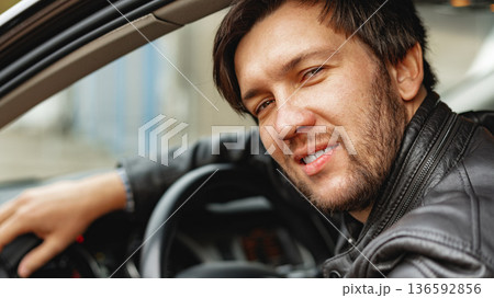 Man driving a car and smiling while sitting in a vehicle on a sunny day Man driving a car and smiling while sitting in a vehicle on a sunny day 136592856