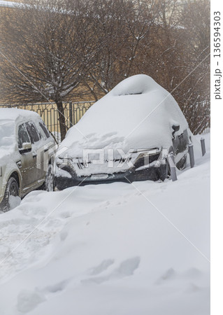 Car completely covered in deep snow during winter snowfall in residential area. Concept of cold weather, vehicle abandonment and seasonal parking difficulties Car completely covered in deep snow during winter snowfall in residential area. Concept of cold weather, vehicle abandonment and seasonal parking difficulties 136594303