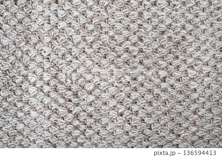 Wool gray crochet blanket as background. Knitted macro texture, close-up of beige crocheted front surface, woolen texture of woolen wool 136594413