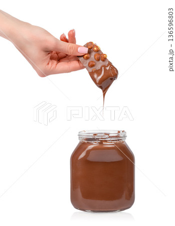 Chocolate Covered Wafer Dipping into Creamy Spread 136596803