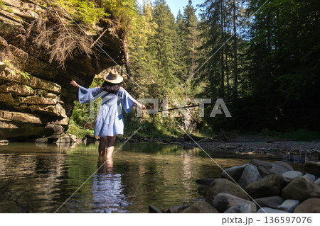 Woman Strolling by River in Forest 136597076