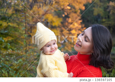 Mother and Baby Smiling in Autumn Park Mother and Baby Smiling in Autumn Park 136597105