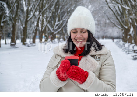 Woman Enjoying Hot Drink in Snowy Park Woman Enjoying Hot Drink in Snowy Park 136597112