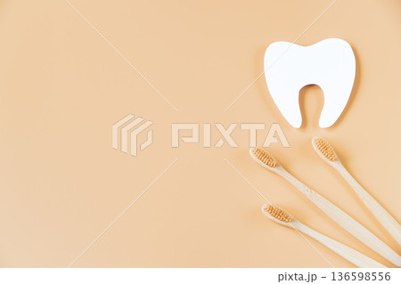 Eco-friendly wooden toothbrushes on trendy beige background. Dental care concept. Happy dentist day. Eco-friendly wooden toothbrushes on trendy beige background. Dental care concept. Happy dentist day. 136598556