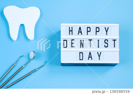 Paper cut mockup of tooth and dental instrument on blue background. Dental care concept. International Dentist Day. Paper cut mockup of tooth and dental instrument on blue background. Dental care concept. International Dentist Day. 136598559